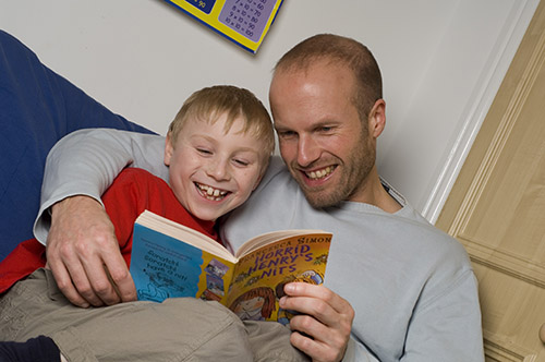 Dad and boy looking at a book together