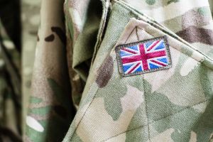 Close up of a camouflaged uniform featuring an embroidered Union Jack flag